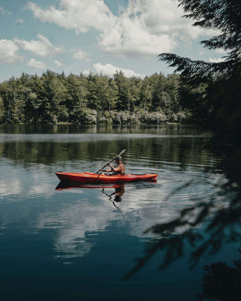 Paddler in a kayak on calm lake water